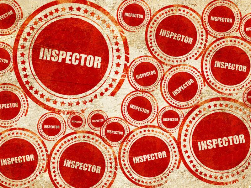 inspector, red stamp on a grunge paper texture