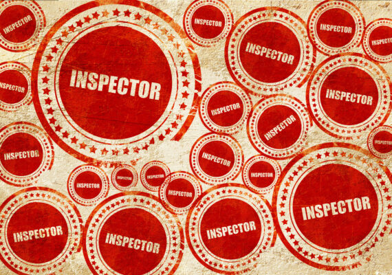 inspector, red stamp on a grunge paper texture
